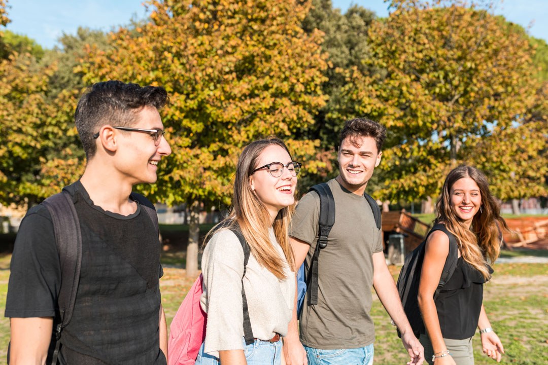 Groupe d'étudiants souriants marchant dans un parc en automne près d'un logement étudiant à Rouen